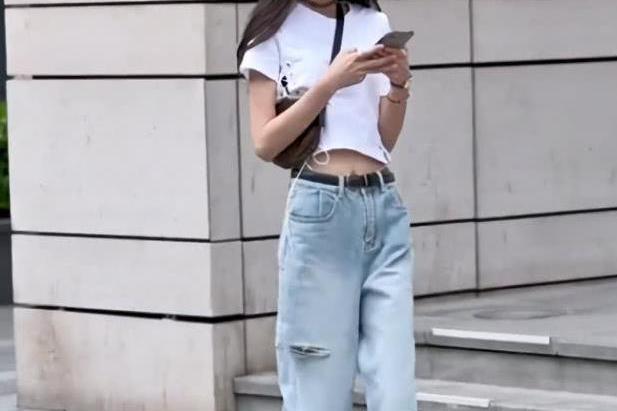 街拍:美女边走路边低头玩手机,这是不小心把裤子给抓破了吗