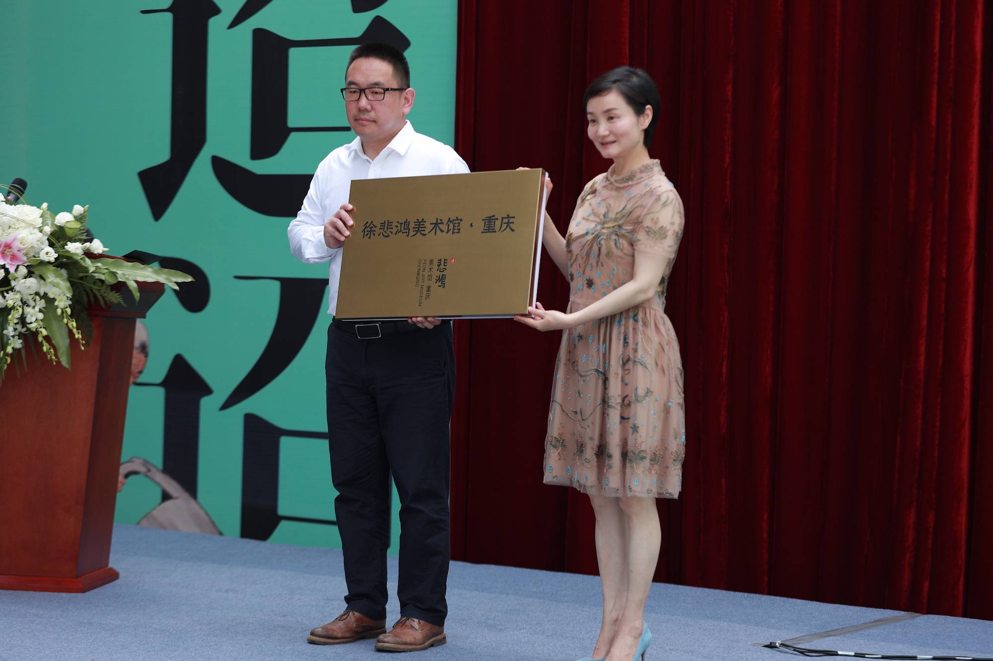 策展人 徐骥(左),江北区人民政府区长代小红(右)向徐悲鸿美术馆·重庆