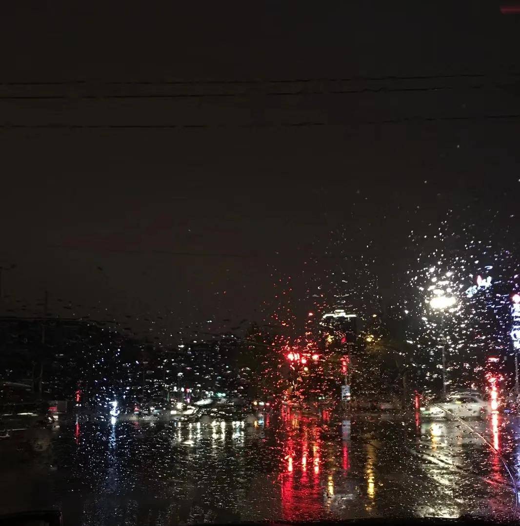 雨天的城市街头在彩色灯光的晕染下增加了几分朦胧.
