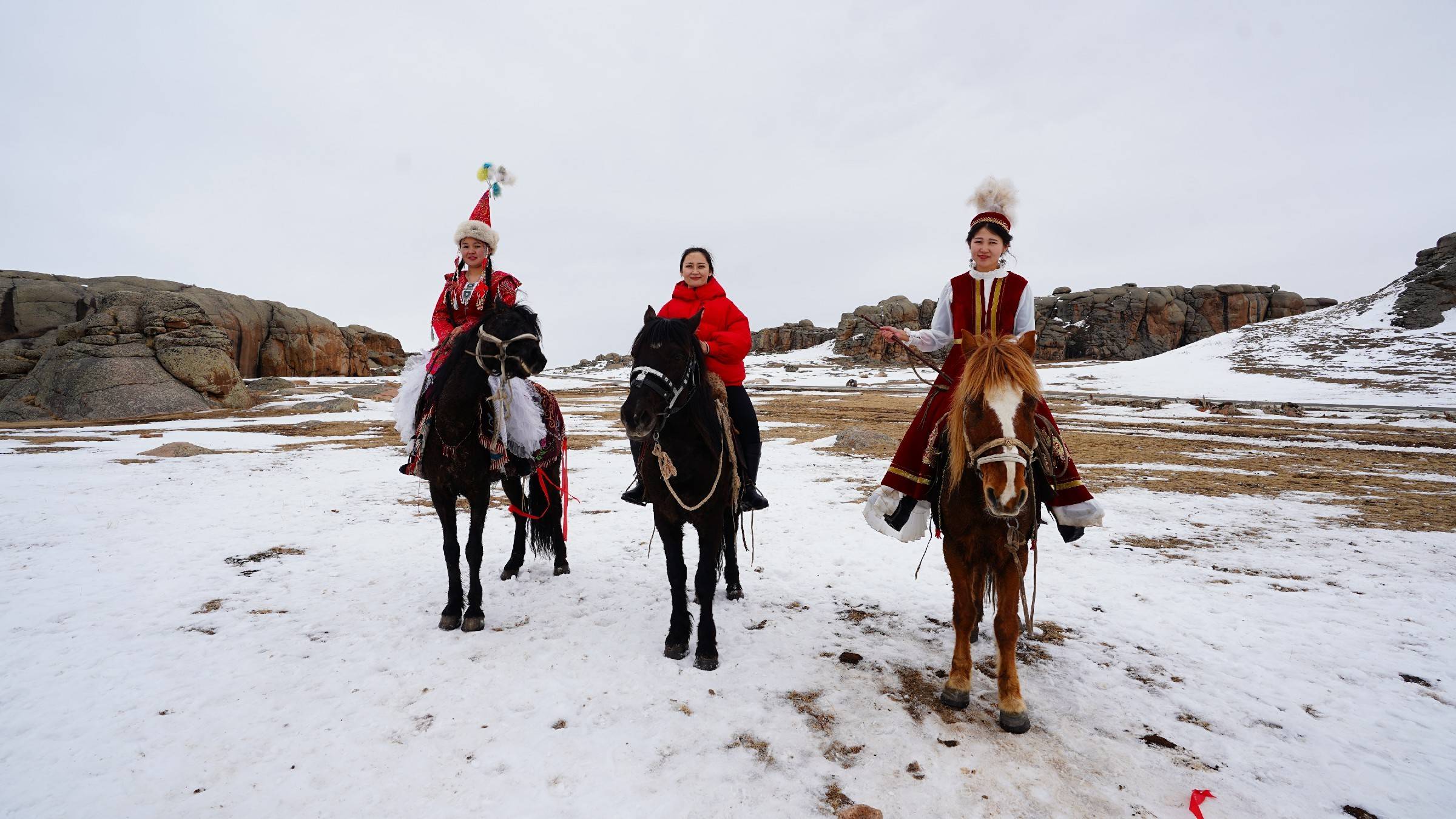 美丽的哈萨克族姑娘骑马漫步在雪地上