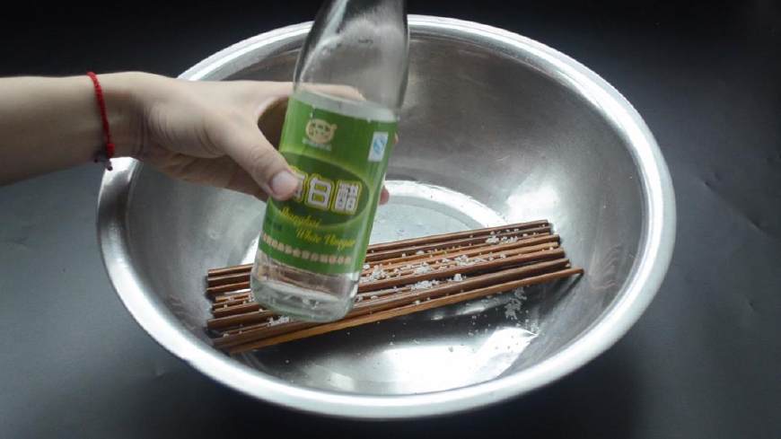 首先把新买的筷子拆开放进盆子里,并且往筷子上倒点食用盐