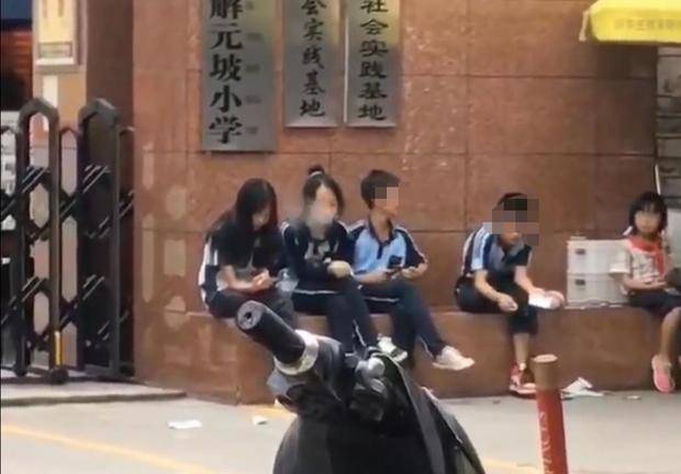 南宁4名学生坐在某小学门口抽烟,举止像足了老烟民,吗
