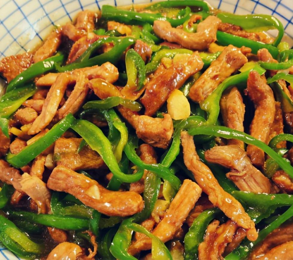 青椒炒肉丝4,炒至青红椒断生,调入白糖,翻炒一下即可出锅.