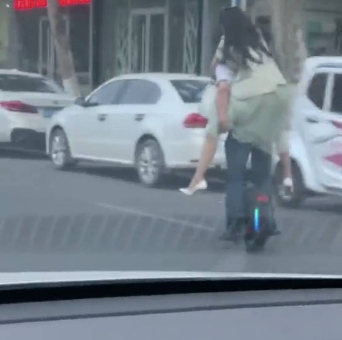 临沂男子背着女友骑着平衡车在马路上疾驰,一个敢骑,一个更敢骑