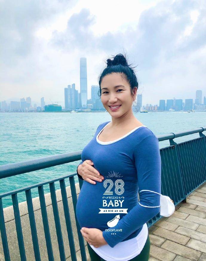原创原创郑佩佩42岁女儿怀孕七个月,扎丸子头挺孕肚拍照,戴口罩路边