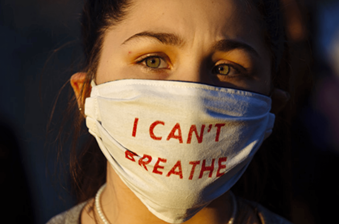 美国明尼苏达阿波利斯市,一名抗议者戴着写有"我不能呼吸"的口罩