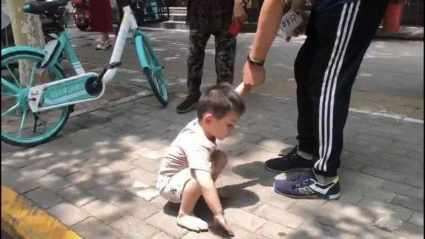 河南:家长不管?三岁小孩赤脚独自在车辆密集的街上"撒欢"!