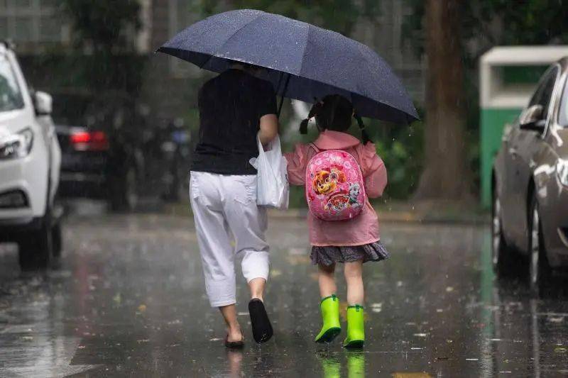 穿着雨衣,雨靴去上学的孩子们.
