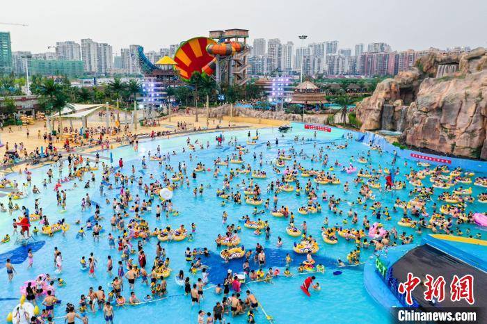 图为7月26日,三名女子行走在南昌玛雅水上乐园 张莹 摄