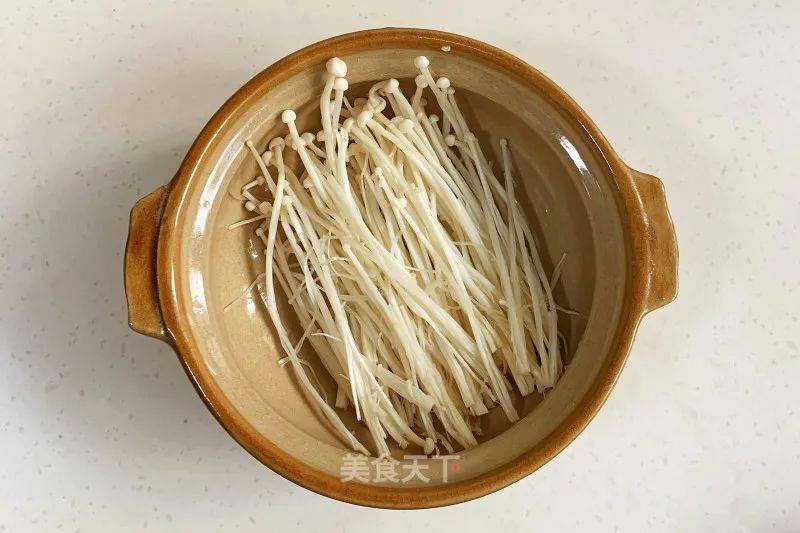 4. 砂锅里面铺上金针菇.