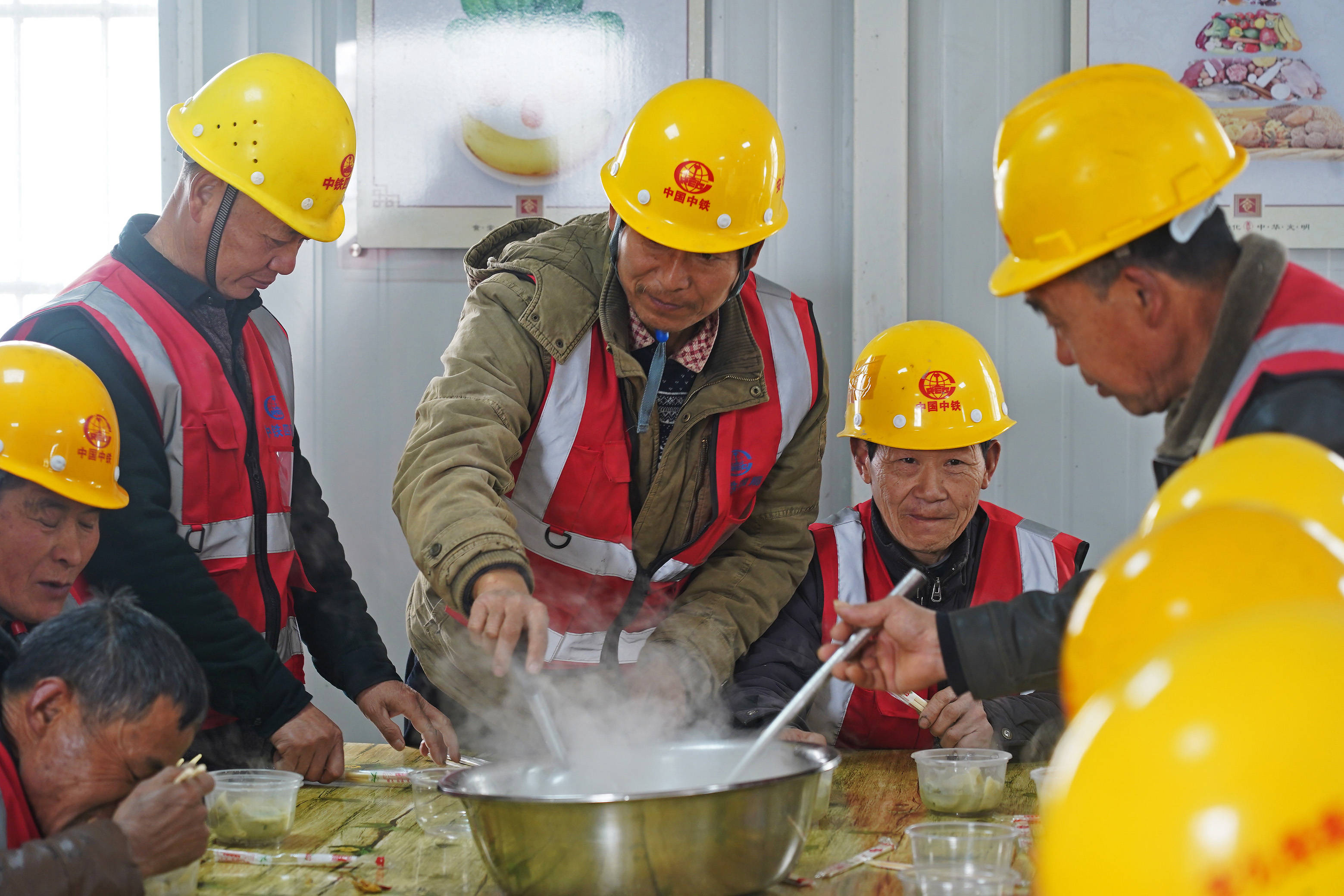 中铁四局建筑工人们在工地食堂聚餐吃饺子(2月4日摄).