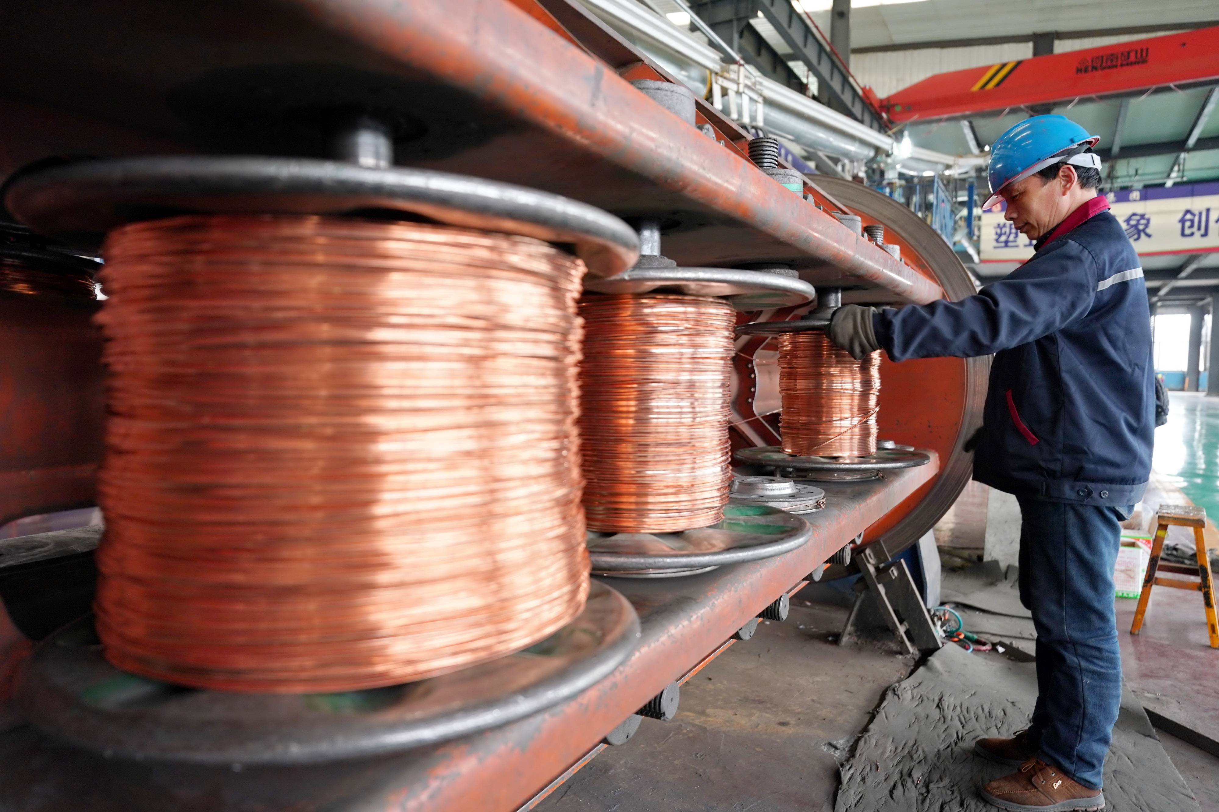 4月22日,工人在河北省宁晋县一家电线电缆生产企业车间内工作.