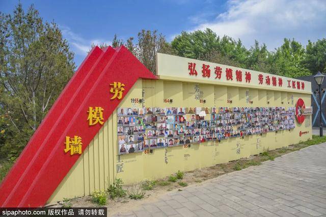 一面贴满劳模照片的劳模墙,展示着北京地铁从业者的风采.