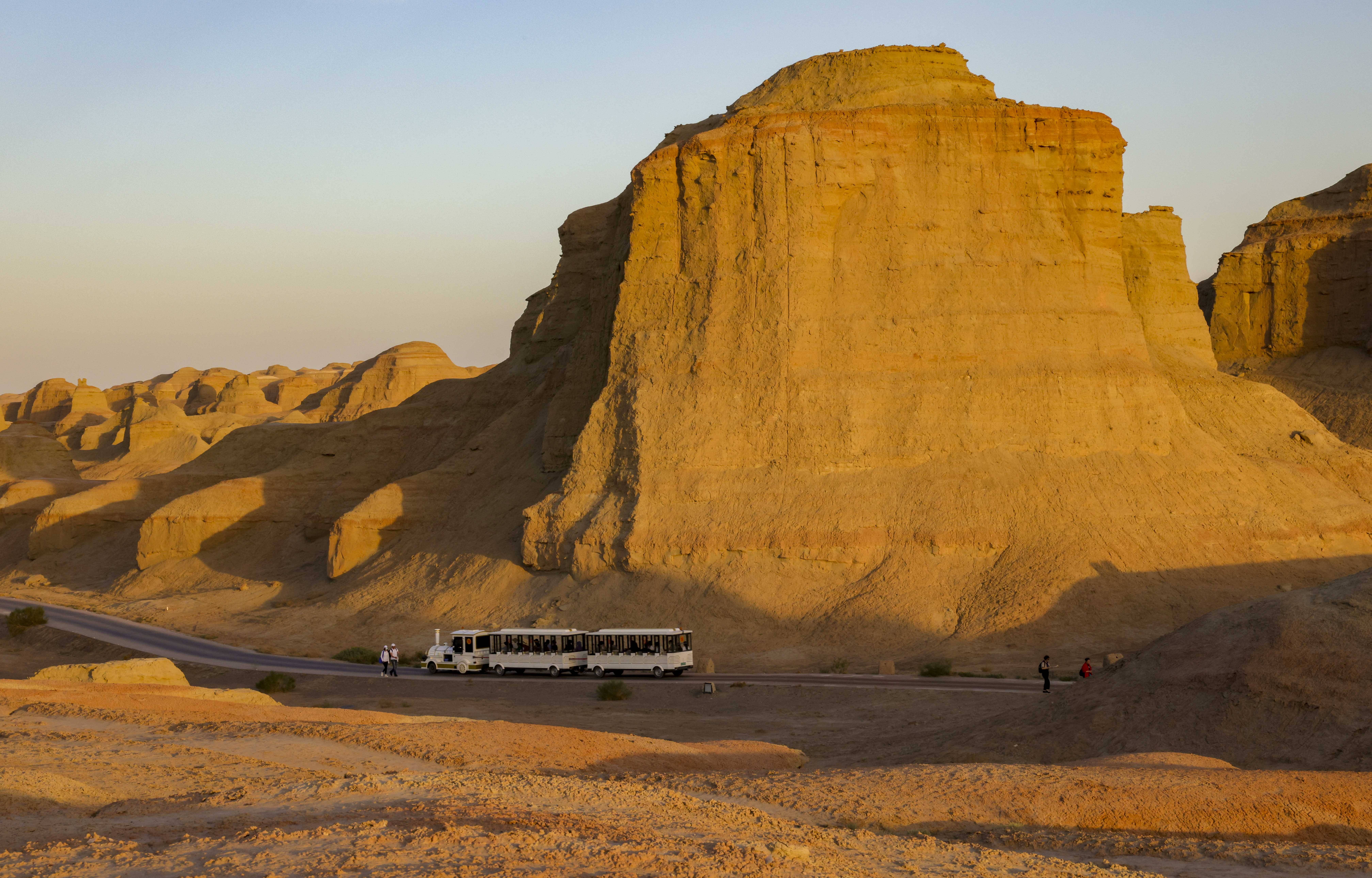 游客乘坐观光车在新疆克拉玛依乌尔禾世界魔鬼城景区内游玩(6月21日摄