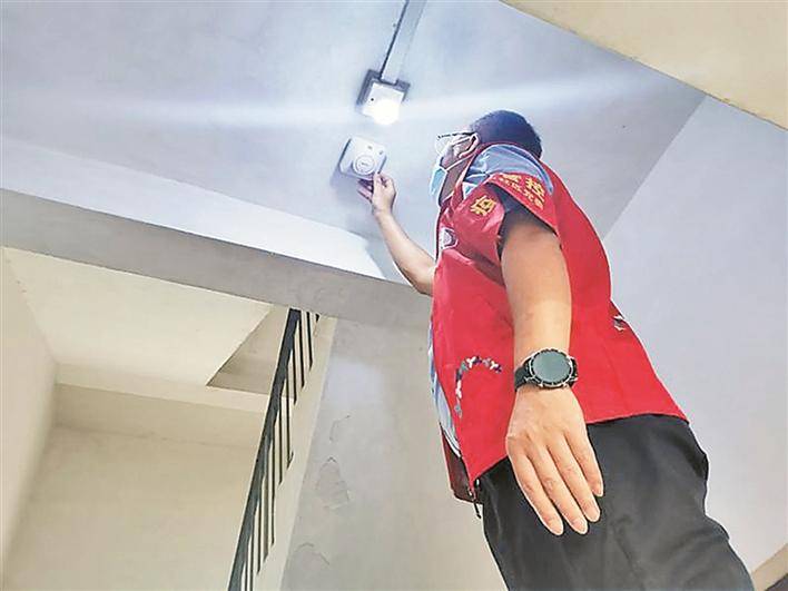 工作人员为居民安装烟感报警器.