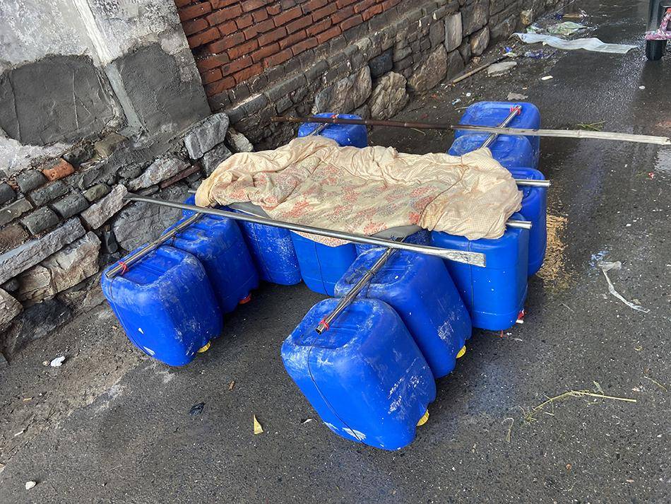 被洪水围困的群众用塑料桶自制的"船".
