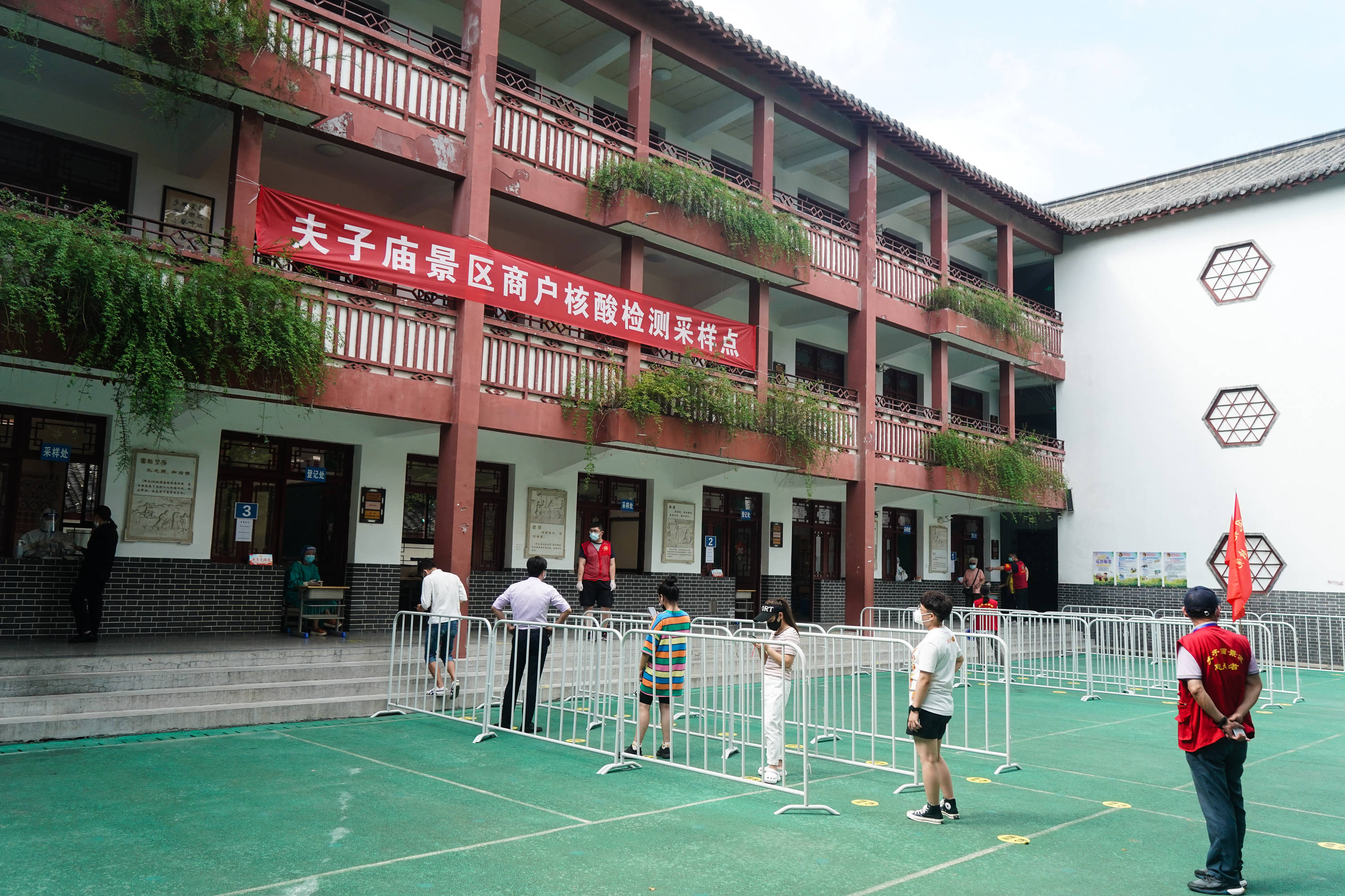 8月5日,人们在南京市夫子庙小学核酸检测点排队接受核酸检测取样.