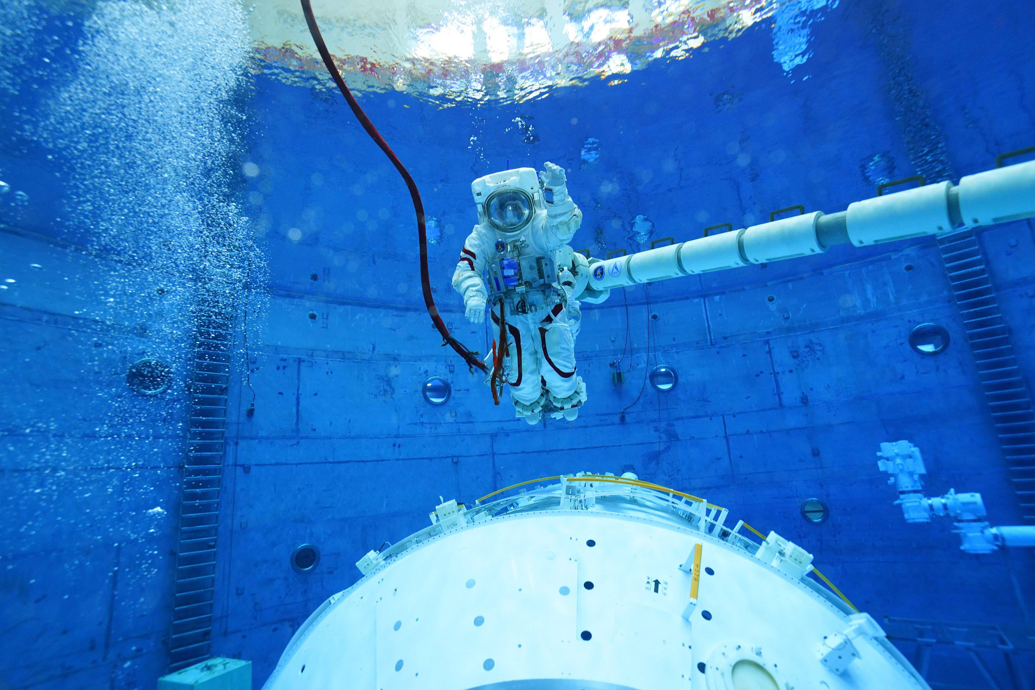 航天员翟志刚水下训练时在机械臂上移动(8月25日摄).