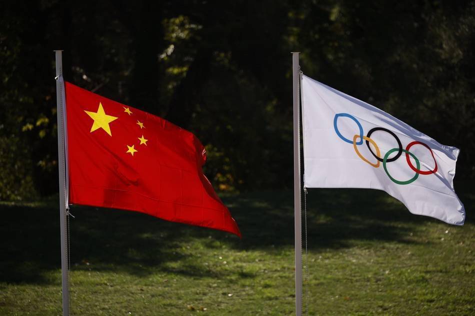 五星红旗和奥运五环旗在北京冬奥会圣火采集仪式上迎风招展.