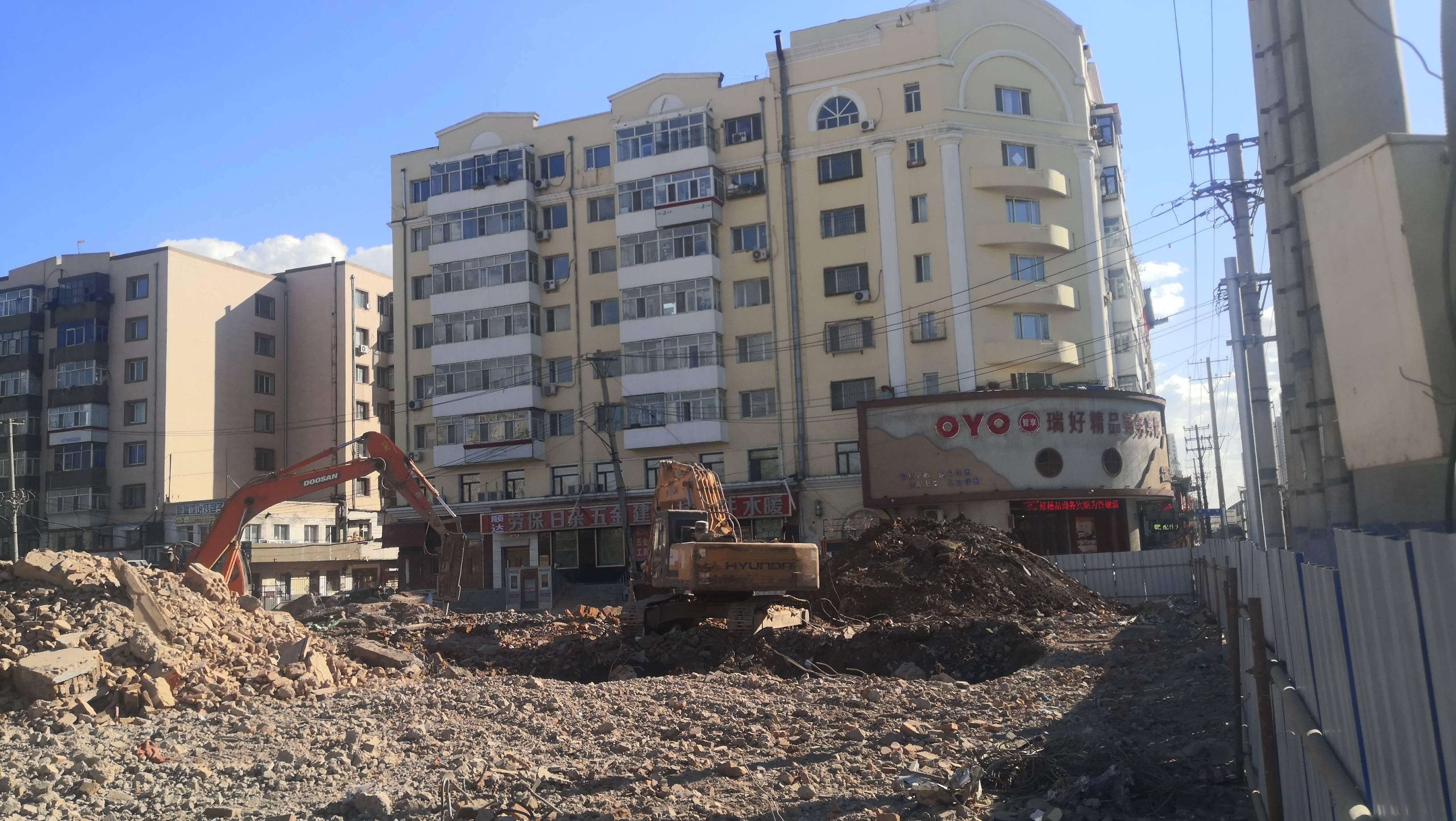 哈尔滨市道外区南直路与东直路交口附近,工人们驾驶铲车拆迁烂尾楼