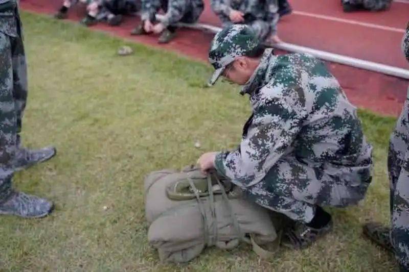 要领:1,将宽背包绳置于被子中央处.