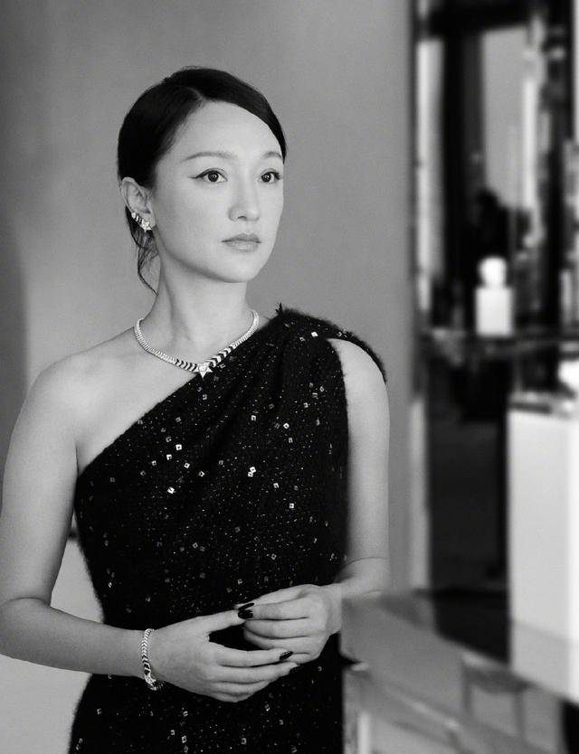 本人周迅纯黑亮片衫神情严肃，一展优雅成熟气质，上挑眼线更添娇媚