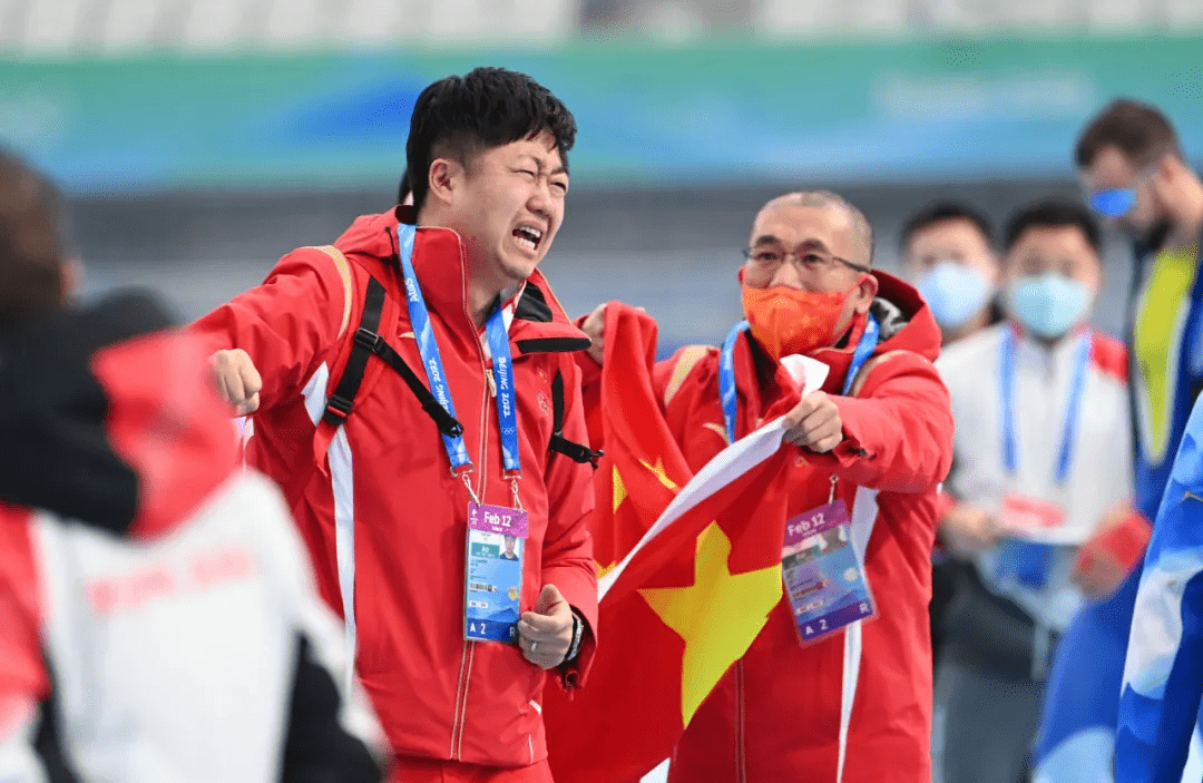 2月12日,中国速度滑冰队主教练刘广彬(左)在高亭宇夺冠后.