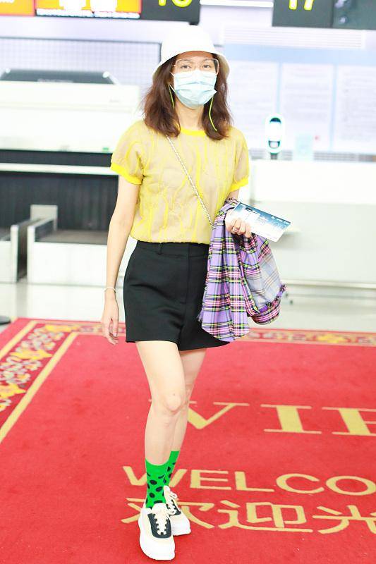 原创38岁高露走机场黄色t恤配黑色短裤简单大方绿色波点短袜抢镜