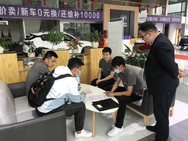 7月23日,一位抢到价值4000元购车电子消费券的顾客在汽车销售市场签订