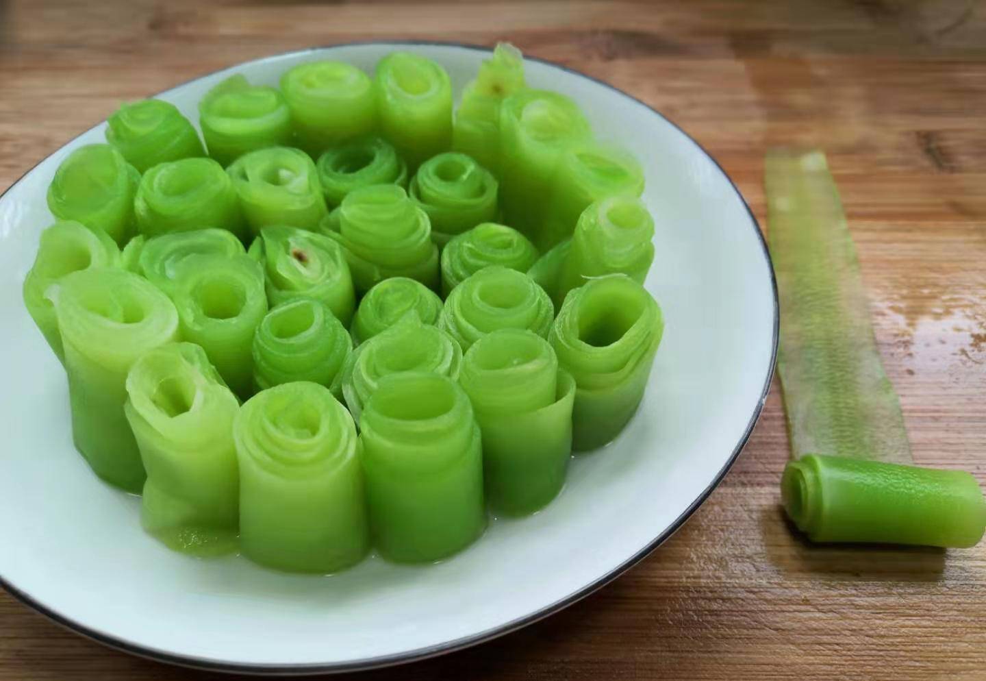 从一头卷至另一头,卷成如竹笋状的卷,全部莴笋卷好摆放在盘中