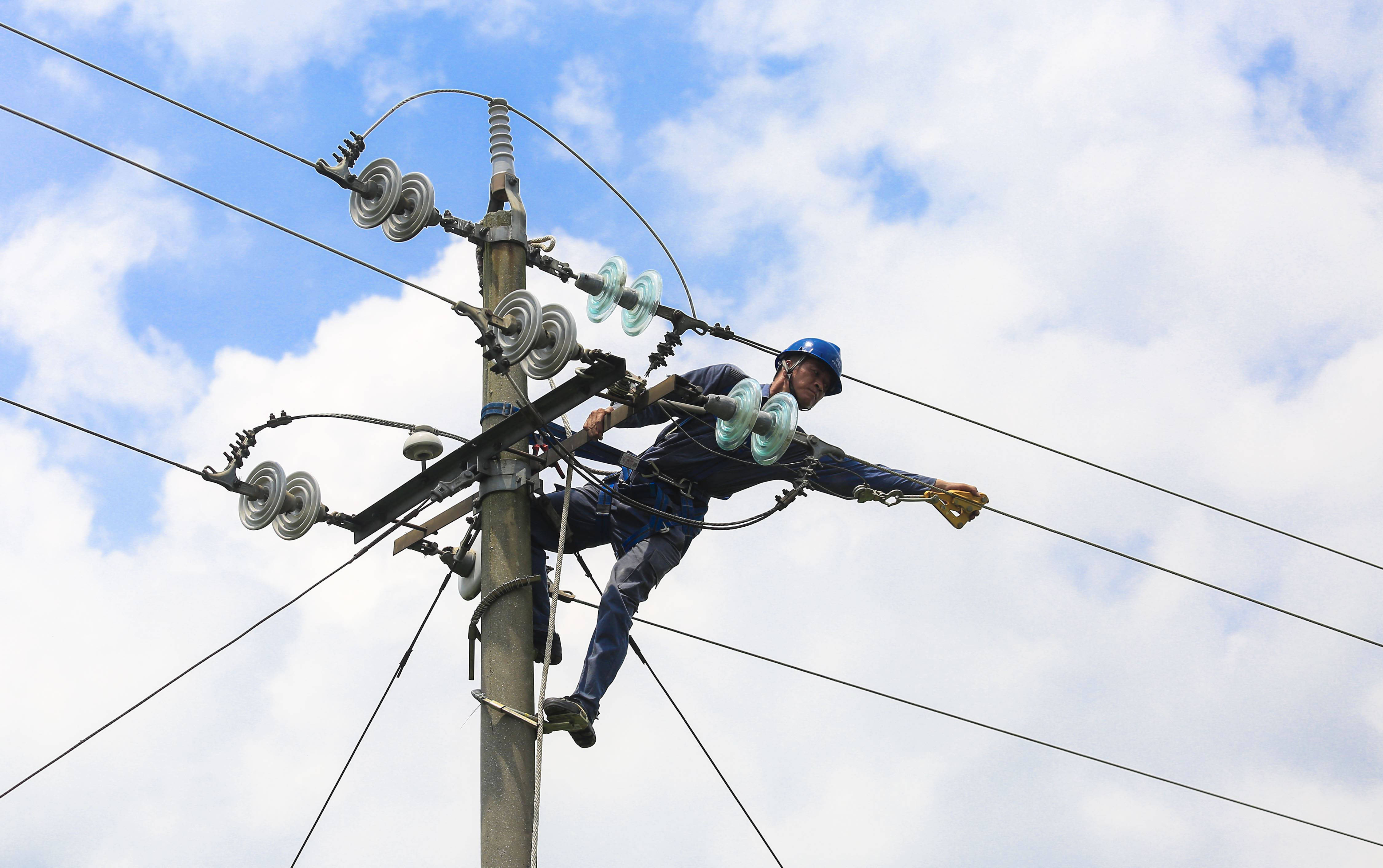 在柳城县大埔镇三塘村,一名电力工人在空中作业.