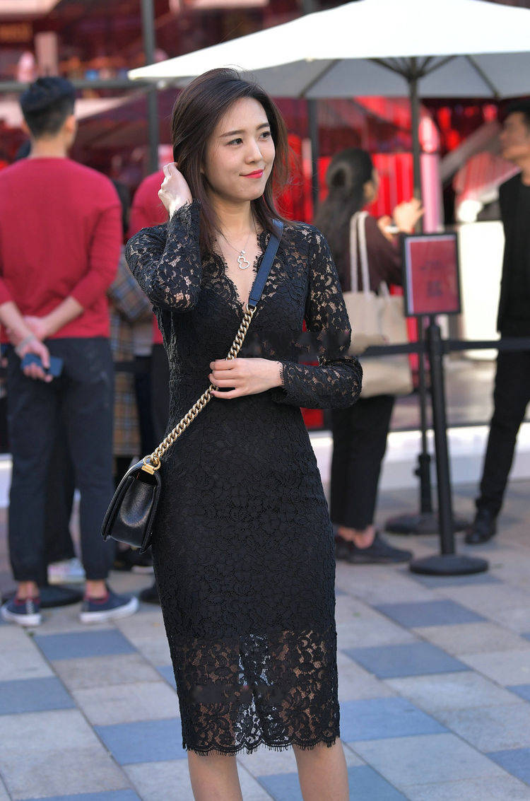 美女街拍小姐姐穿的是一件黑色的蕾丝连衣裙提升整体的优雅气息