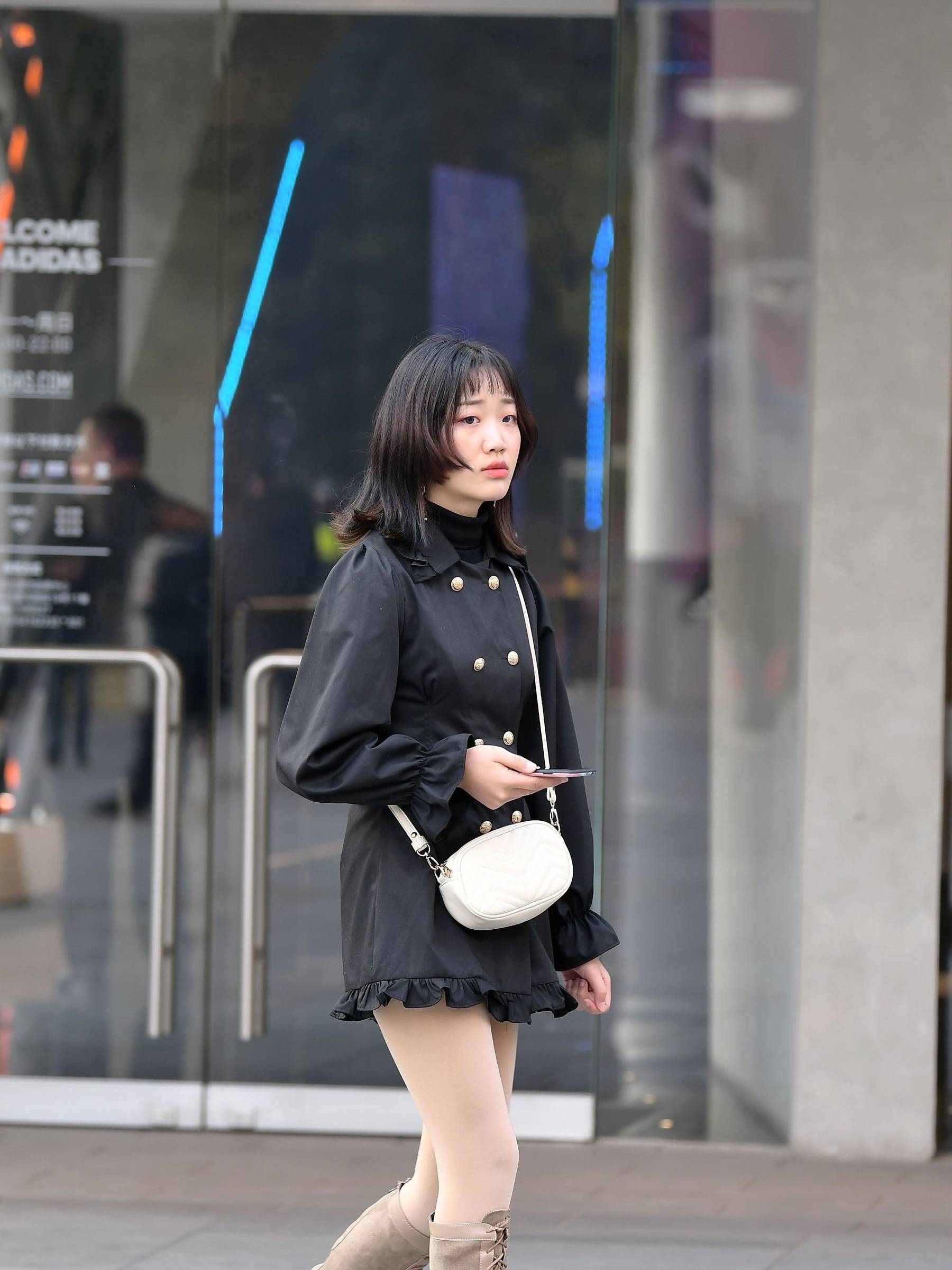 街拍:小姐姐穿着一件黑色连衣长裙,侧面开叉,有一份优雅的感觉