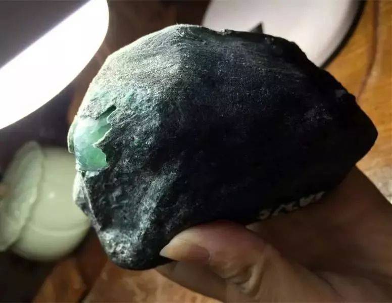 一块黑皮的翡翠原石一刀切出高冰翡翠起货后真的是光彩夺目