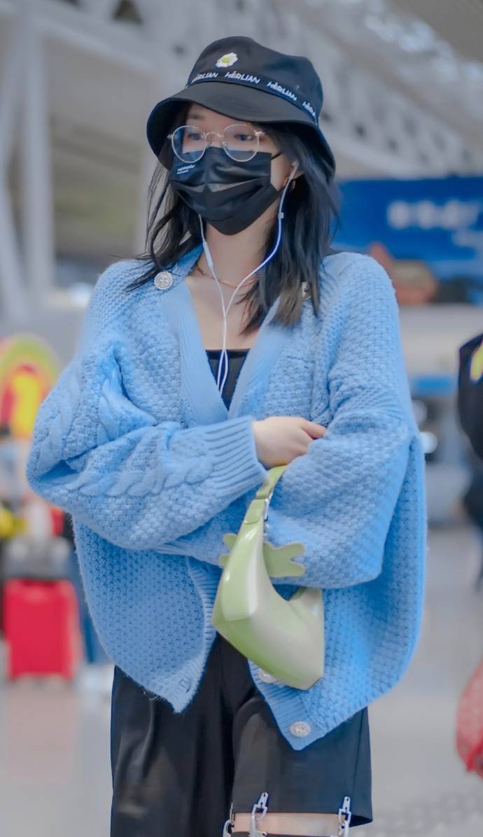 程潇近日机场穿搭,黑色低领内衫搭配蓝色背扣毛衣,清新的颜色搭配彰显