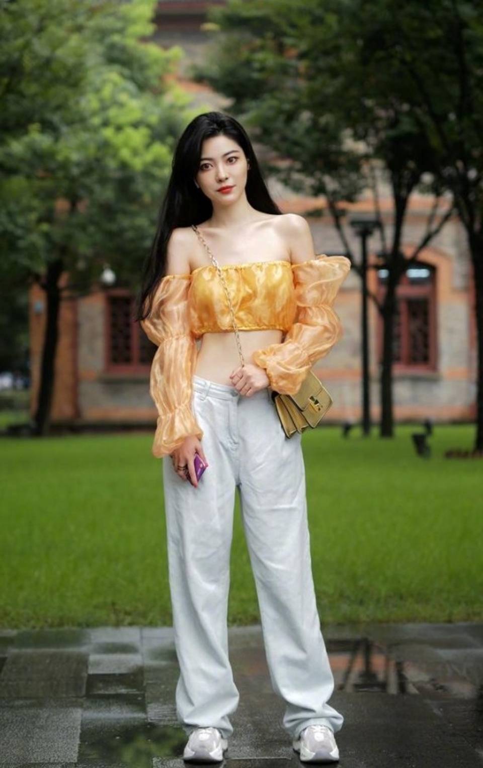 路人街拍,美女一件橘黄色的长袖抹胸上衣,洋溢着青春的气息