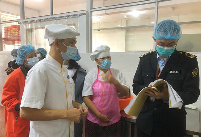 工作人员正在检查各餐厅食品安全管理制度情况.
