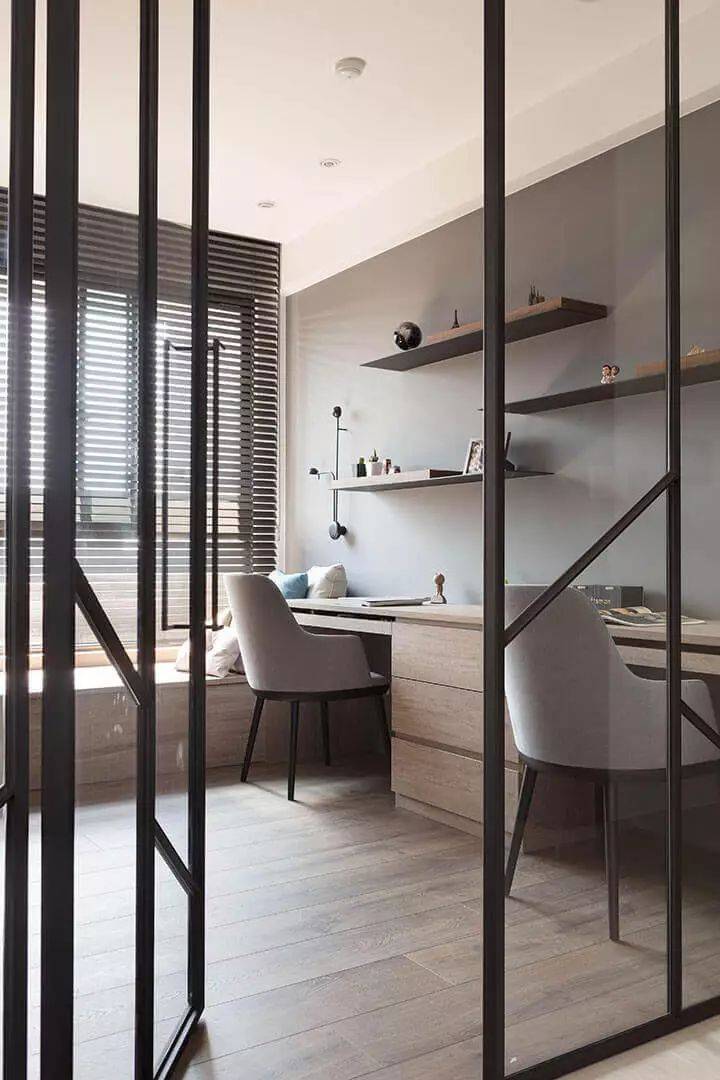 玻璃门后的书房区域,定制木质书架与书桌,布置双人位的办公位,让