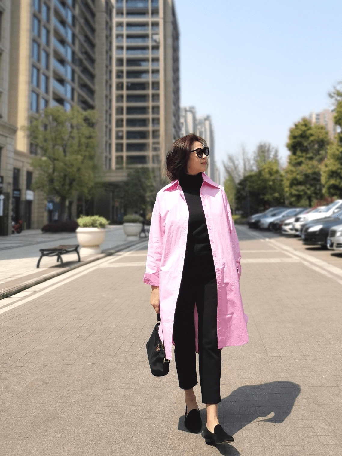 内搭全身黑色服装,以粉色风衣为艳色点缀,高调又有压制感.