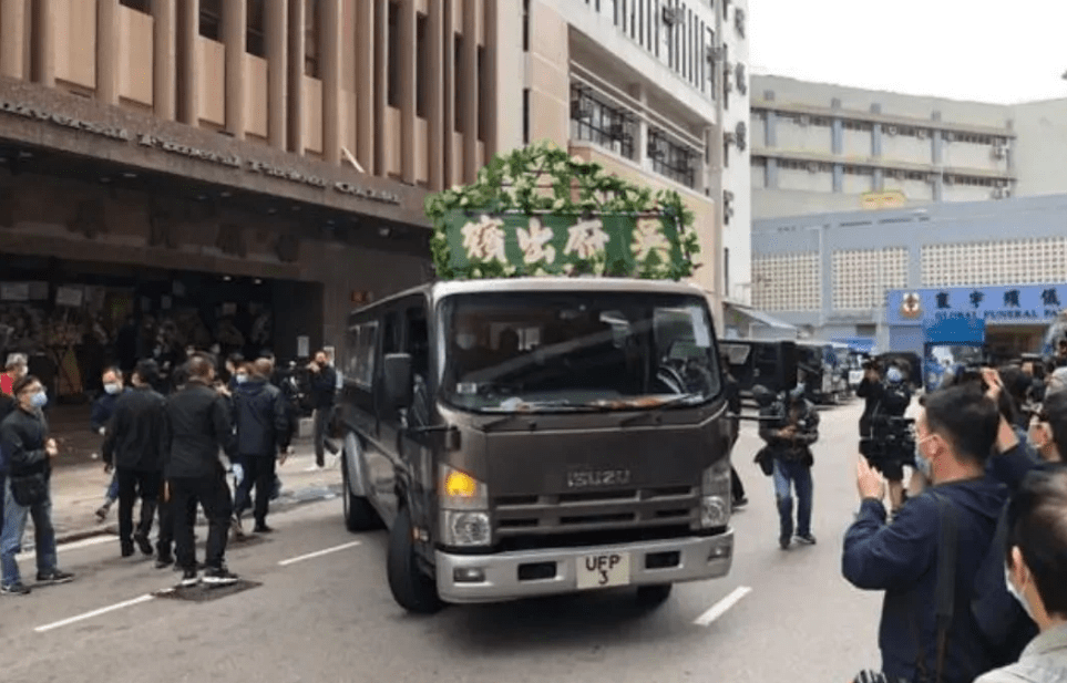 原創吳孟達出殯遺體被眾人抬上黑色靈車小兒子手捧遺像滿面悲傷