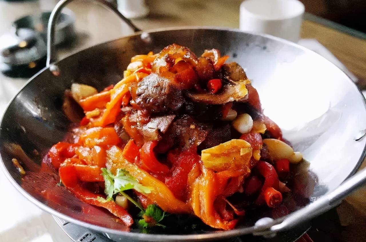 烧辣椒牛肉3,锅底留10克底油,下蒜苔,芹菜梗,蒜蓉,干辣椒大火炒香,再