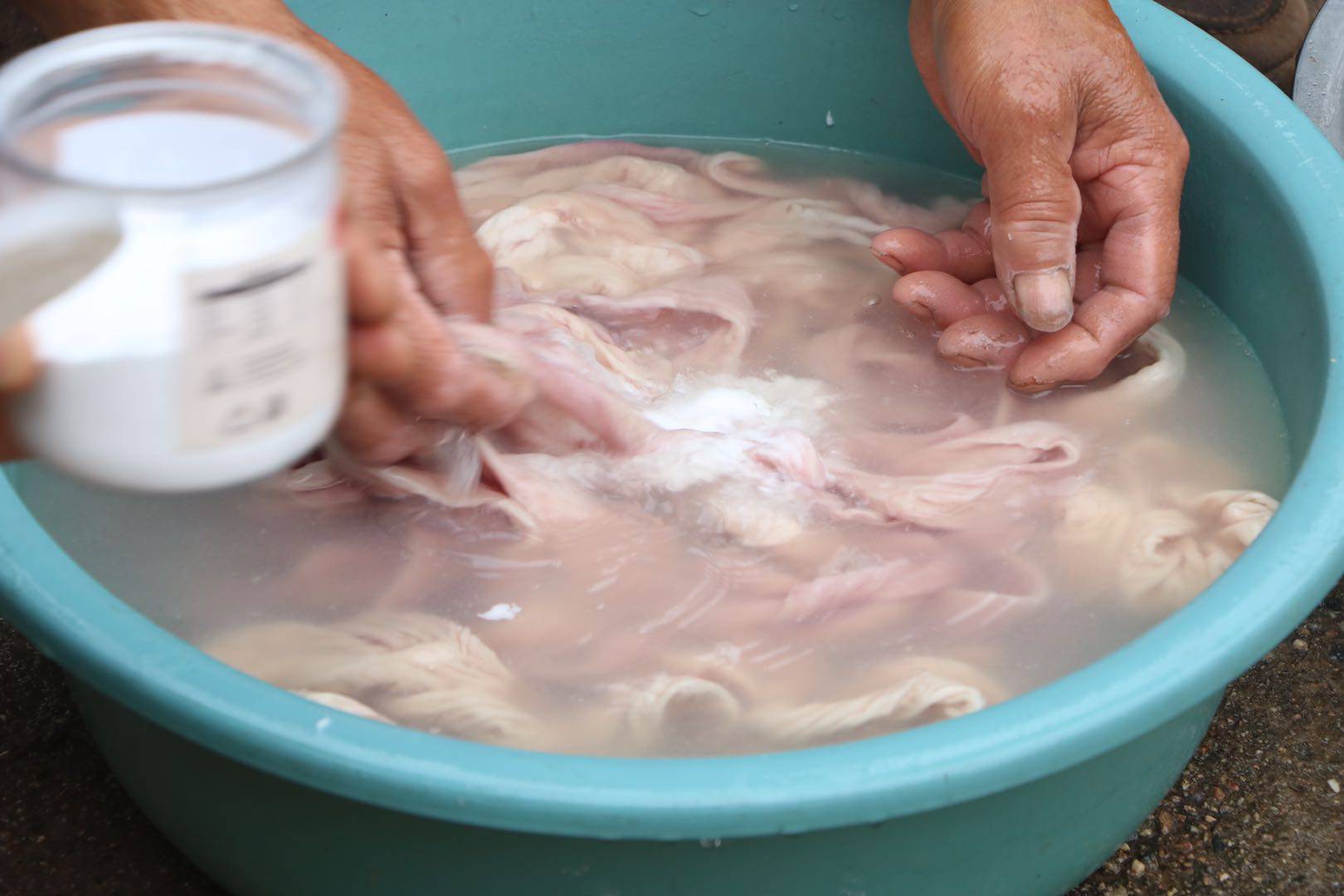 然后加食用碱和开水继续揉搓,加碱能够把猪肠子里的粘稠的脏东西清洗