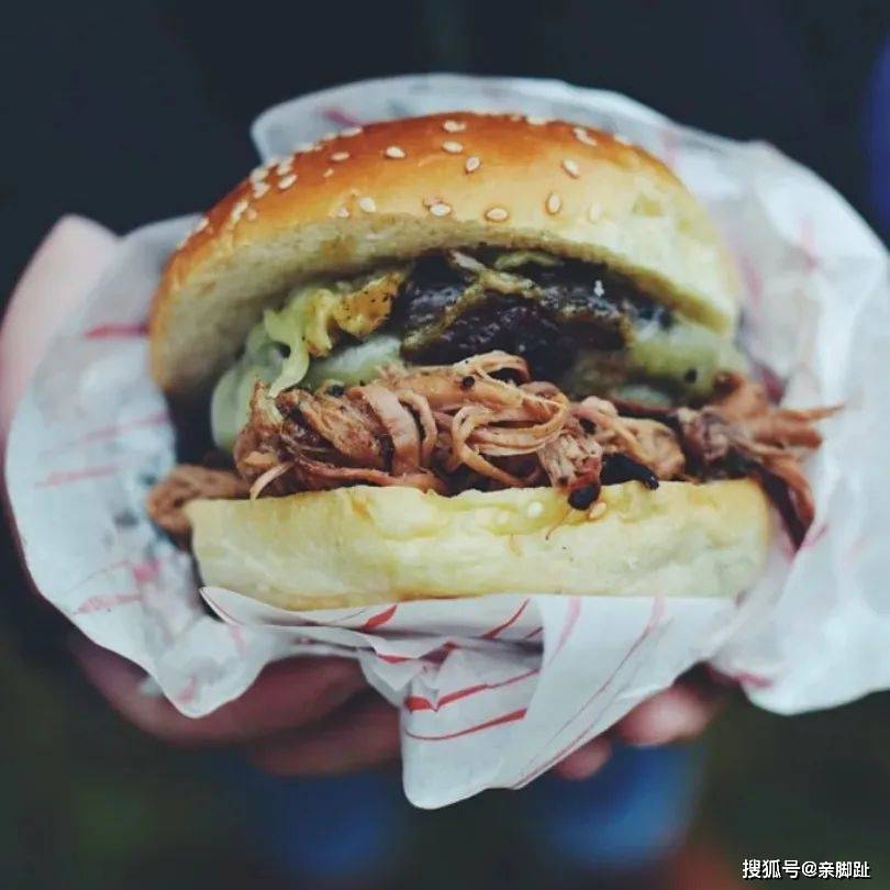 他小心翼翼地拆开包装,小口地咬了一下汉堡,嚼了吞下以后对我感激地笑