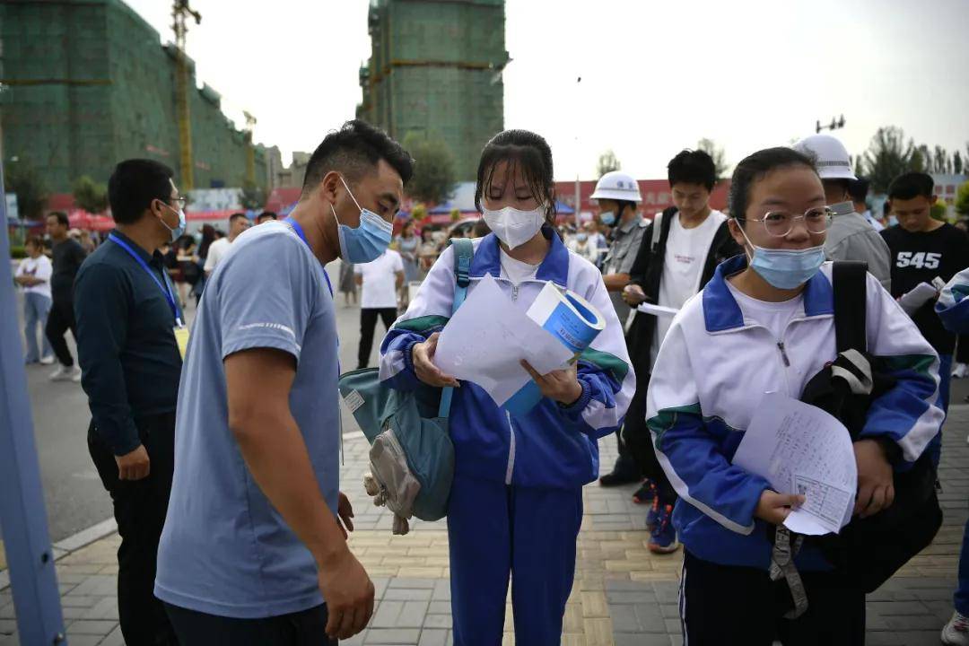 经过测温通道,正式进入考点按顺序走进学校大门考生们戴着口罩在老师