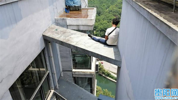 坐在悬空平台的男子