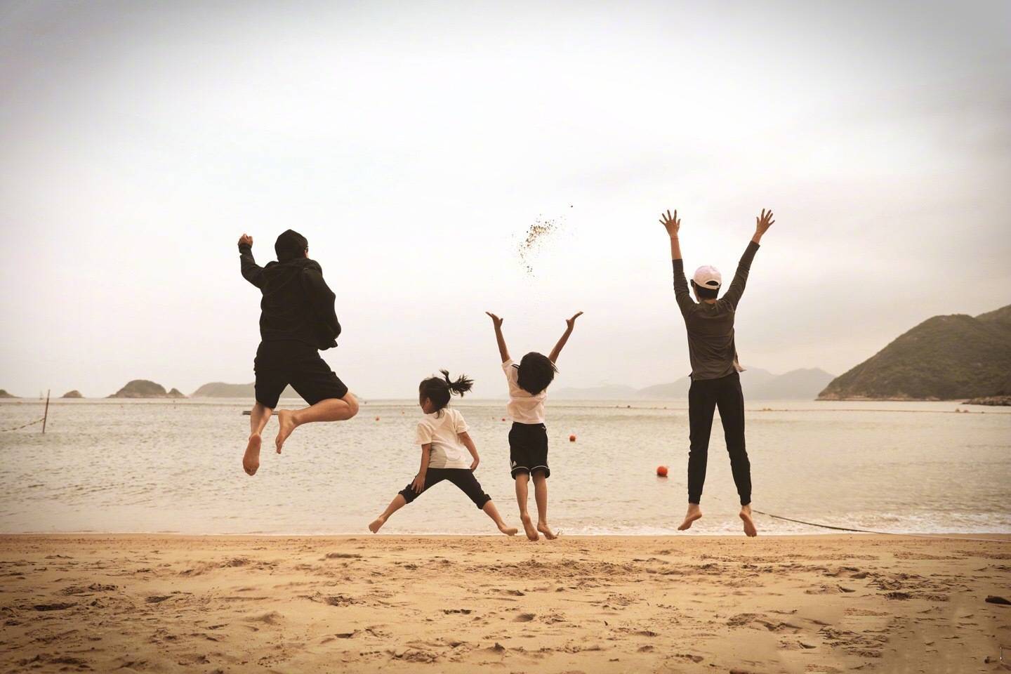 孙俪晒海边度假照,一家四口在沙滩上一跃而起,画面幸福温馨