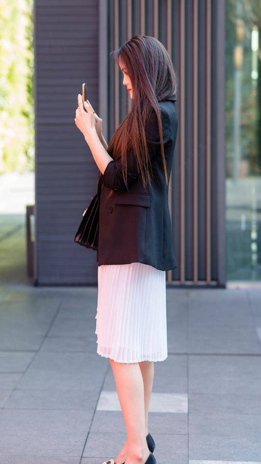 显得|黑西装、百褶裙搭配尖头细跟鞋，展现精致感十足的职业女性气质