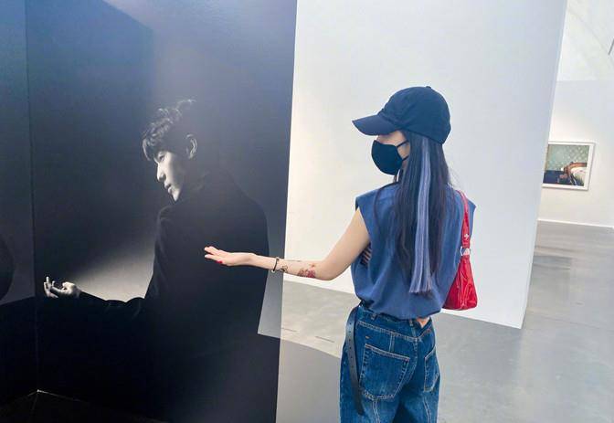 展真|杨幂遛弯看展真悠闲，穿无袖反手大花臂抢镜，见自己海报俏皮合拍