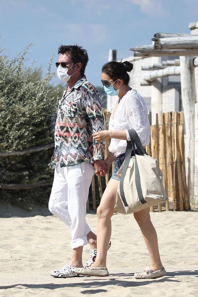 老公|巩俐与老公海边度假,扎丸子头配短裤霸气不再,71岁老公非常时尚