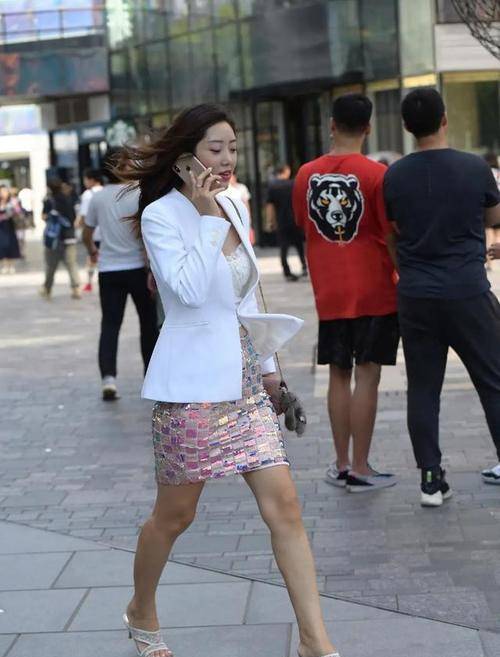 女生 彩粉色的亮片半身裙，外搭一件白色的西装，既优雅又帅气